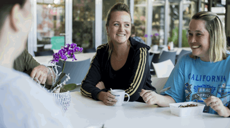 Medewerkers drinken koffie aan tafel