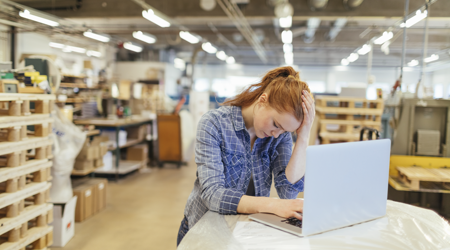 Meisje zit met stress achter haar laptop