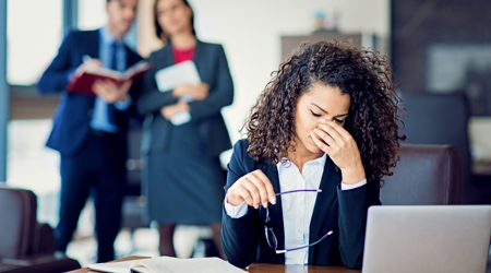 Een vrouw wordt gepest op het werk door haar collega's