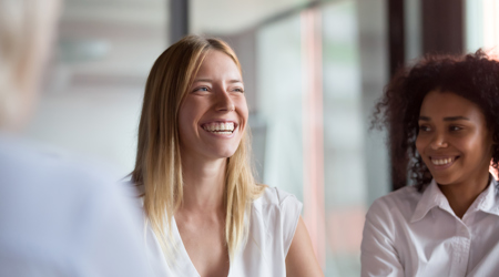 Een lachende vrouw op kantoor met haar collega's