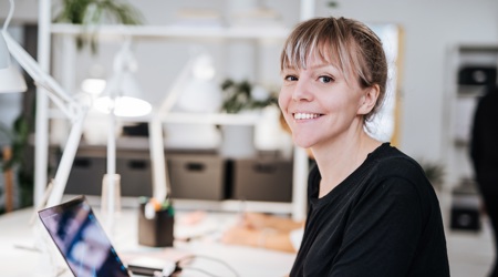 vrolijke medewerker op kantoor achter een bureau
