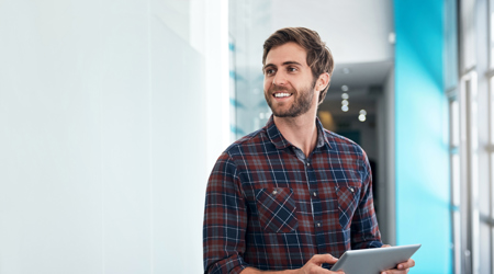 Calamiteitenverlof - Jonge man op kantoor met een tablet in zijn handen